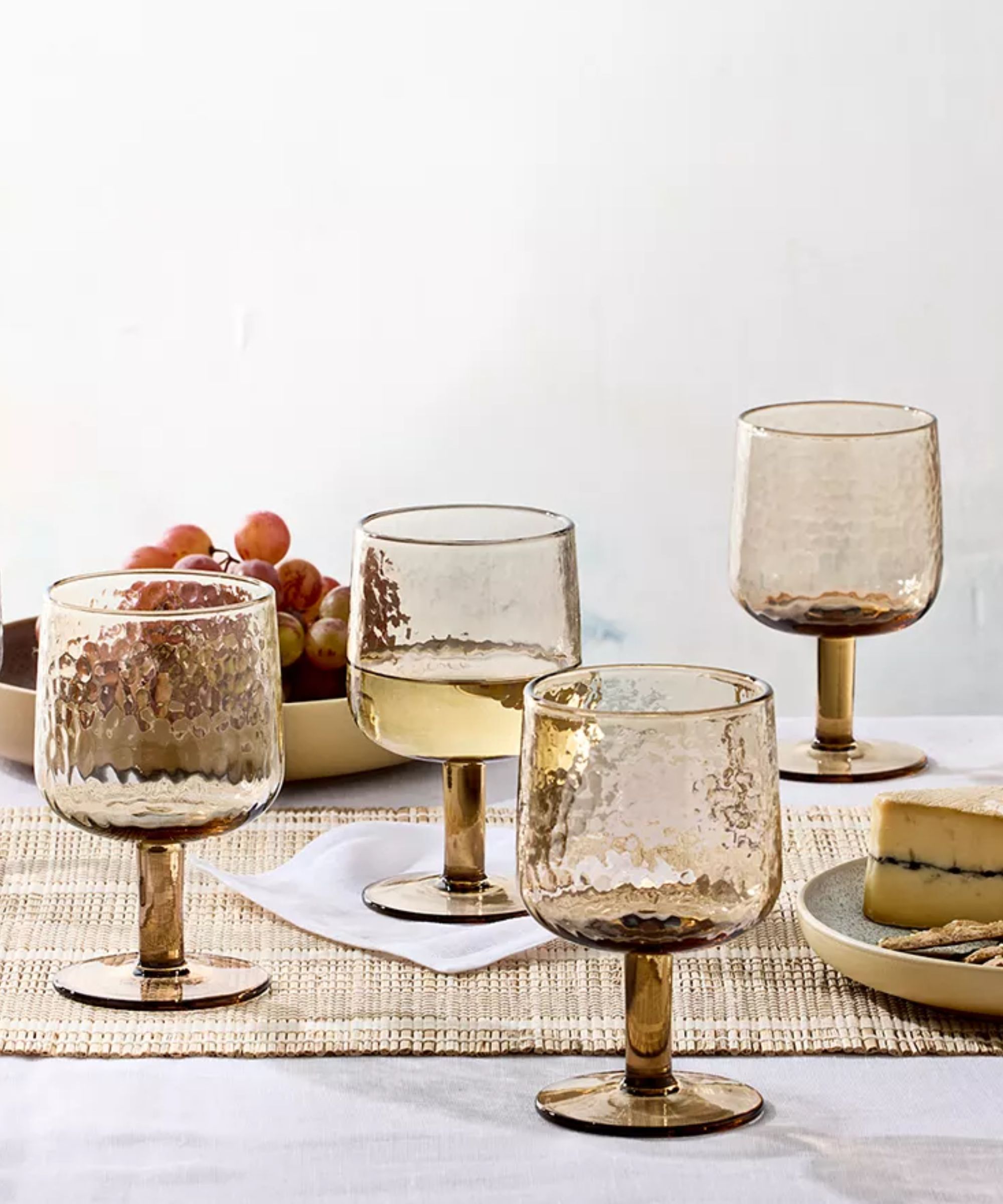 Table with rattan runner and hammered amber wine glasses