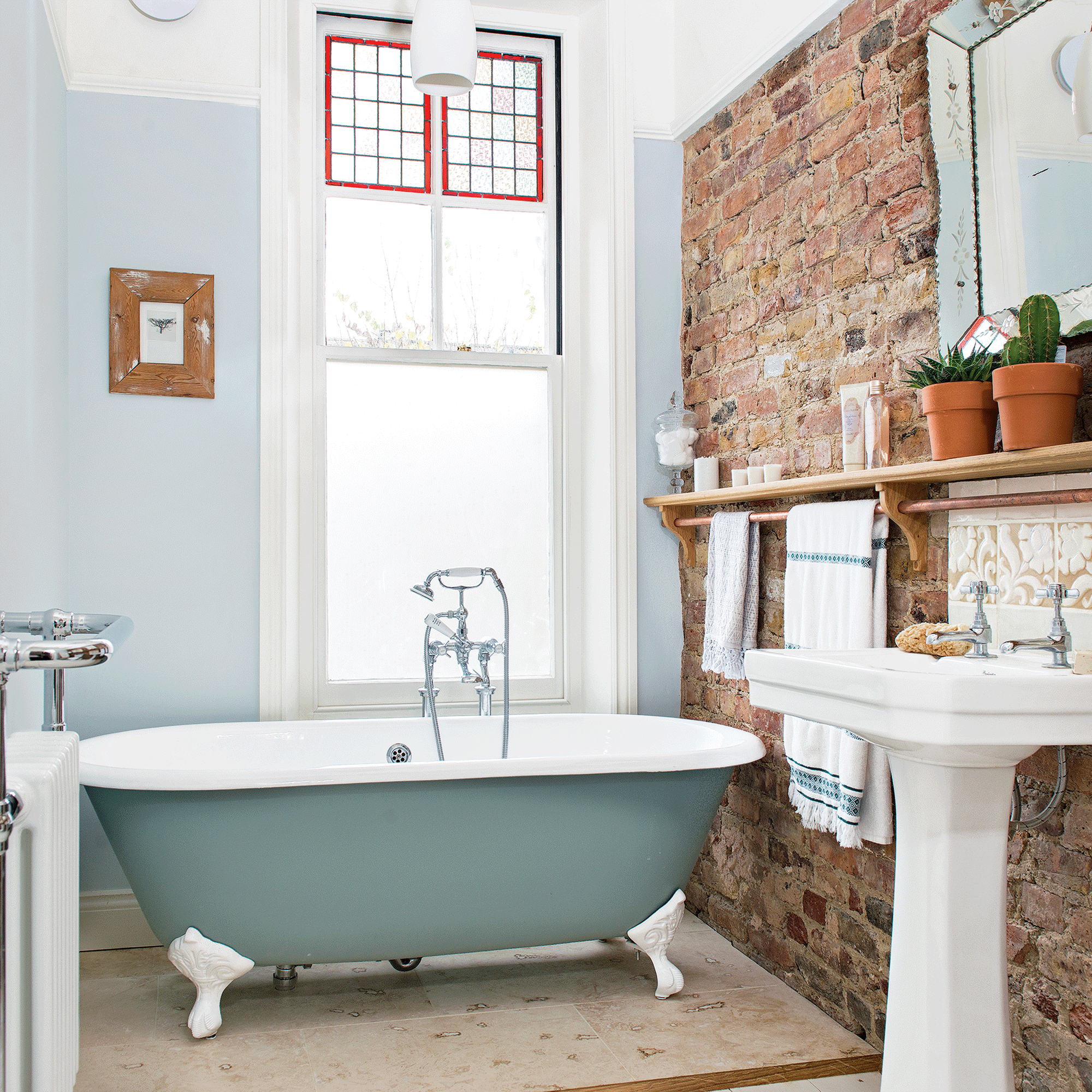 Green bathtub with light blue wall and brick wall