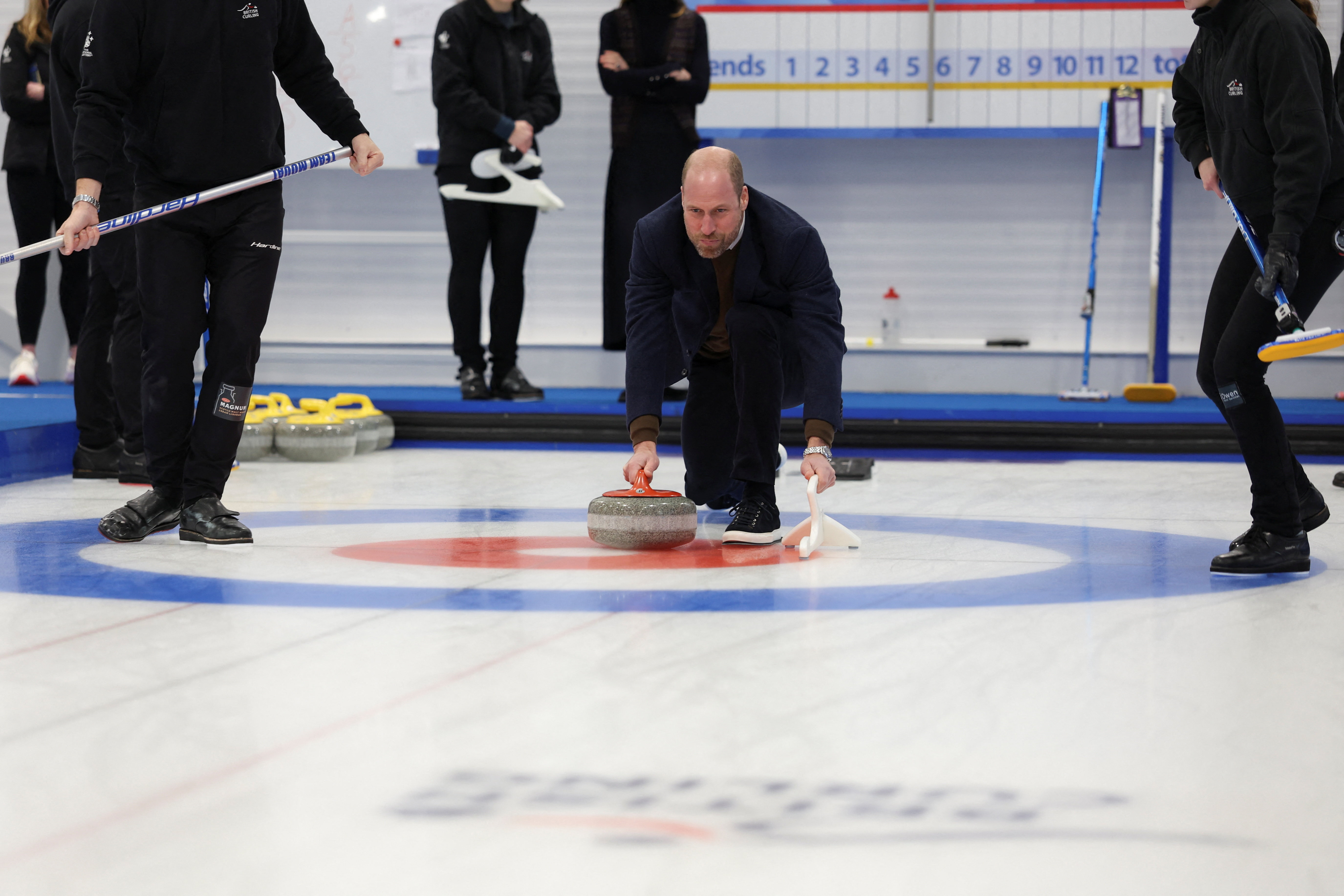 Prince William kneeling playing curling on ice