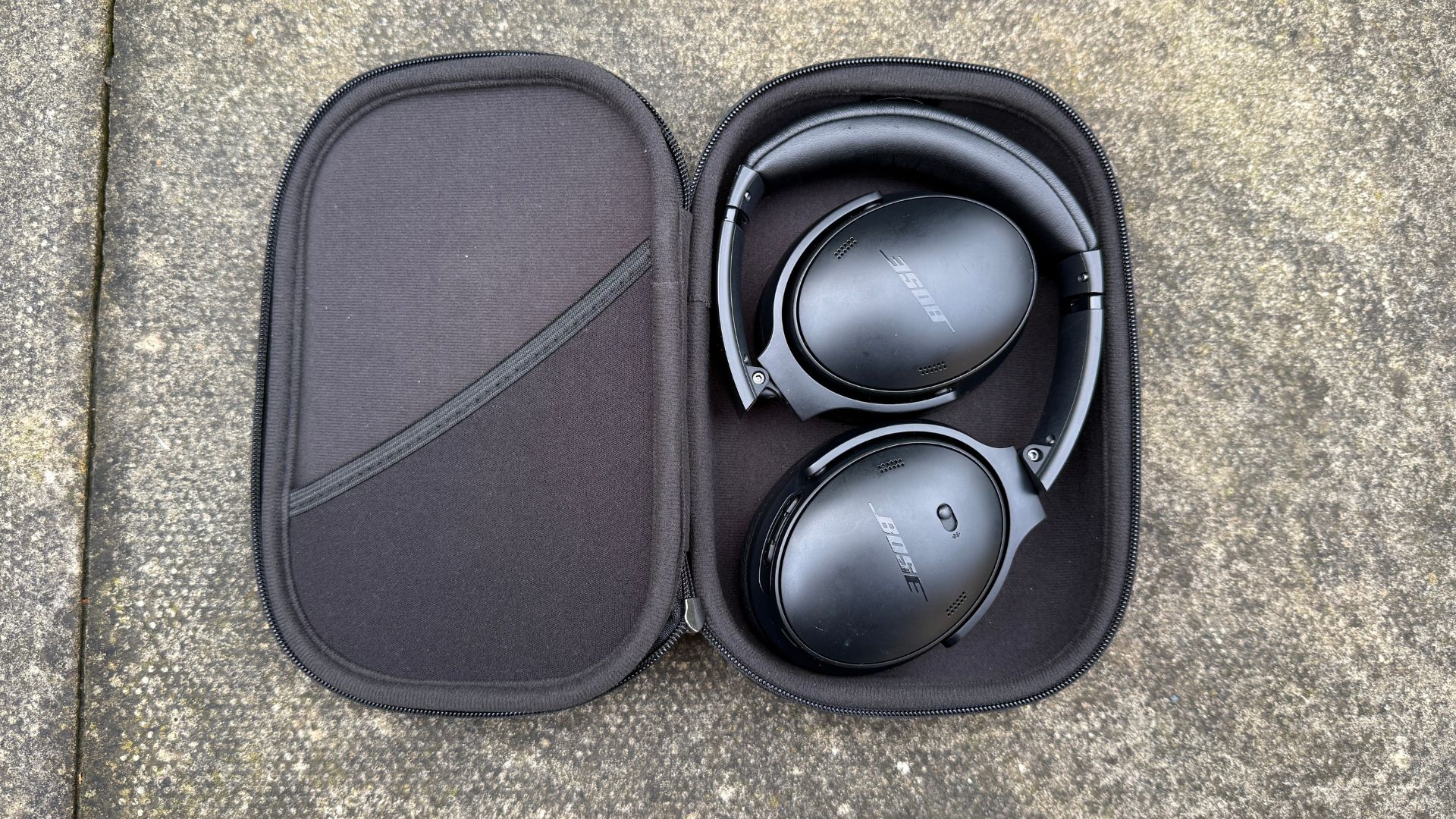 The Bose QuietComfort headphones inside their open case.