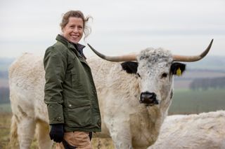 Laura Corbett, goat farmer, Wiltshire. She is pictured here two of her rare breed White Park cattle. Photograph: Millie Pilkington/Country Life Picture Library OVERS