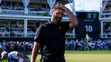 Jon Rahm walks off the green without his cap