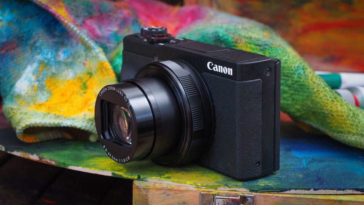 Canon PowerShot camera on a painting table, with colorful paint-covered rags 