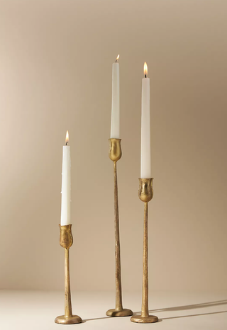 tall gold candlesticks holding tapered handles