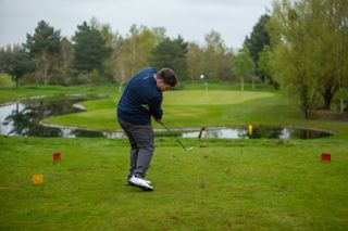 A golfer swings whilst wearing the Payntr shoes