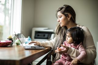 Mum working at home with child on her lap