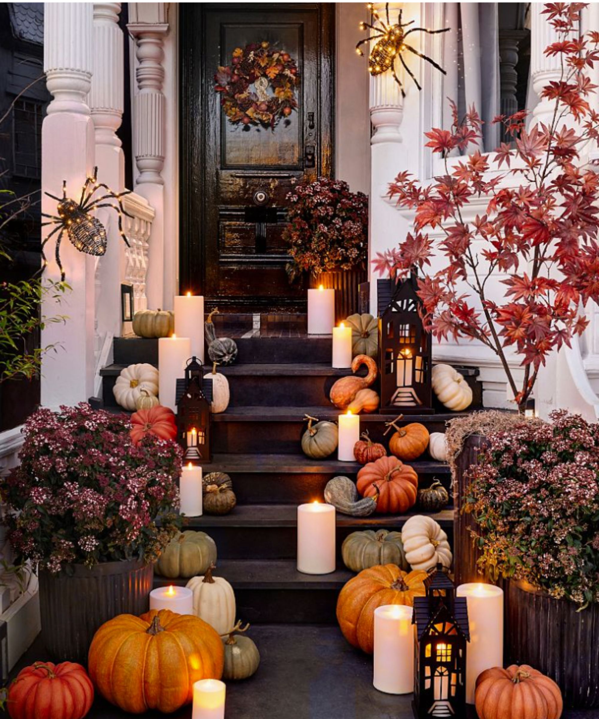 Porch steps decorated with pumpkins and candles