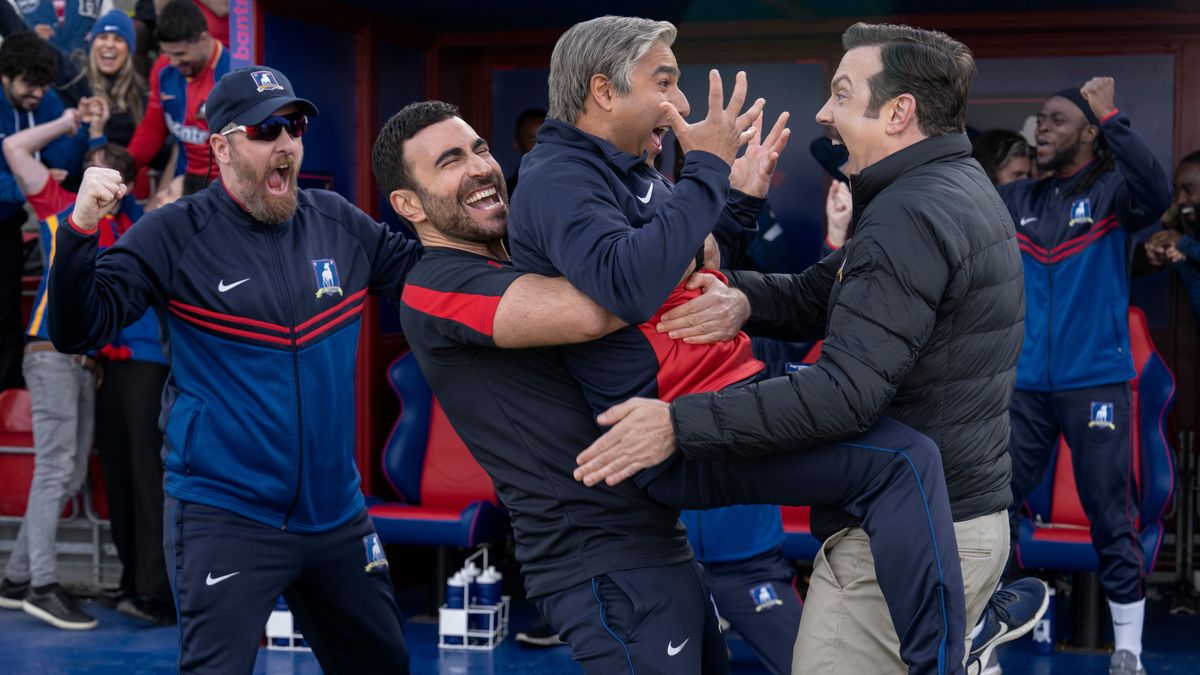 Coach Beard (Brendan Hunt), Roy Kent (Brett Goldstein), Nate Shelley (Nick Mohammed) and Ted Lasso (Jason Sudeikis) (L-R) celebrate pitchside in &quot;Ted Lasso&quot; season 3.