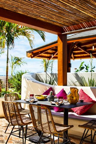 Outdoor seating area with bamboo roof and wooden chairs