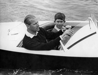 Prince Charles of Wales with his father Prince Philip of Edinburgh on board a boat