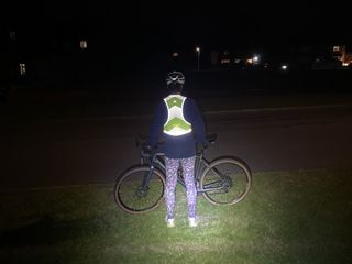 The Apidura Packable Visibility Vest at nighttime with lights being shown on it
