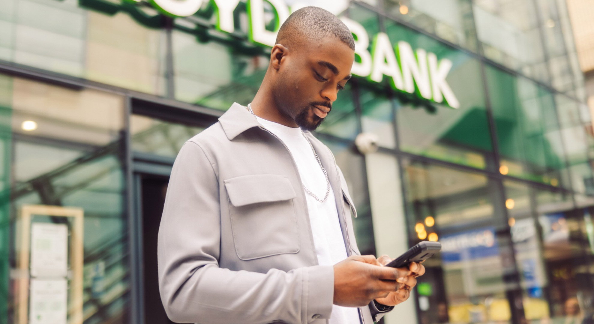Man with phone outside Lloyds Bank