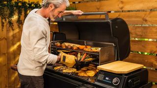 Traeger Timberline wood pellet grill being used by an adult male