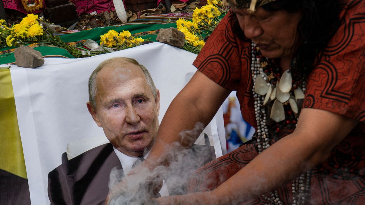 Shamans performing a ritual of predictions for the coming year display a poster of Russian President Vladimir Putin in Lima