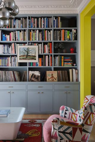 Built in bookcase painted grey with vivid yellow woodwork