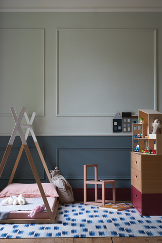 A bedroom with half wall painted blue and the other half painted light green