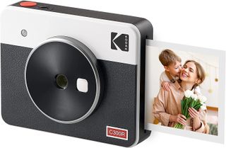 En svartvit Kodak Mini Shot 3 Retro med en utskrift färdig på ena sidan visas mot en vit bakgrund.