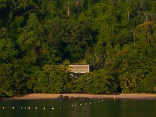 casa paraty, a home by the beach, peeking out from behind foliage in the Brazilian jungle