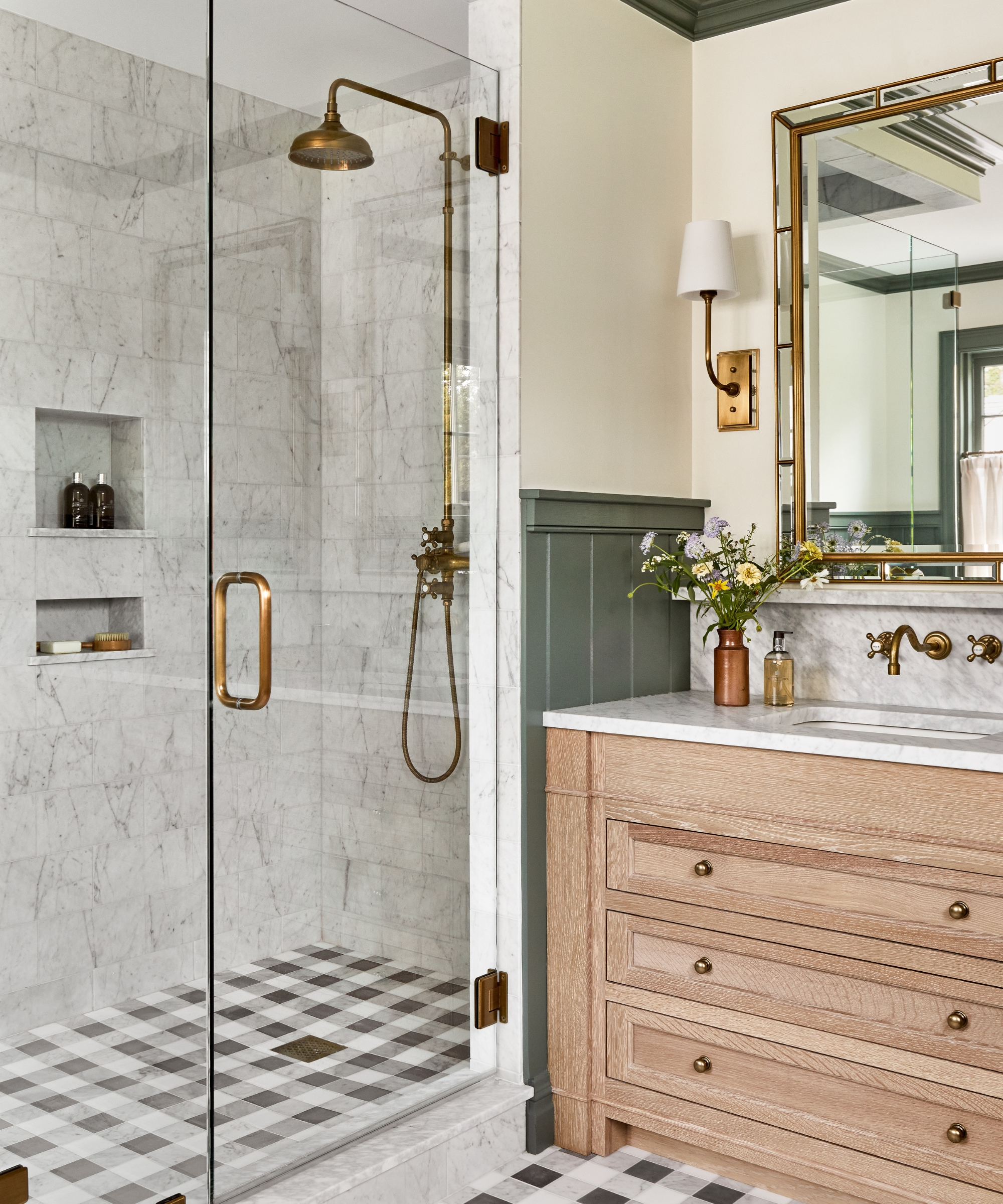 A modern bathroom with marble wall tiles, a wooden vanity, and black and white gingham floor tiles