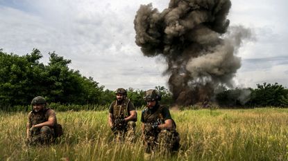 Ukrainian soldiers supervising the controlled explosion of a landmine