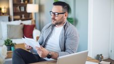 A do-it-yourself investor looks over financial paperwork at his desk at home.