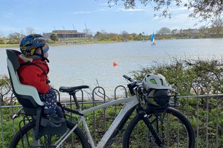 child sat on rack-mounted kids bike seat looking out for the ducks