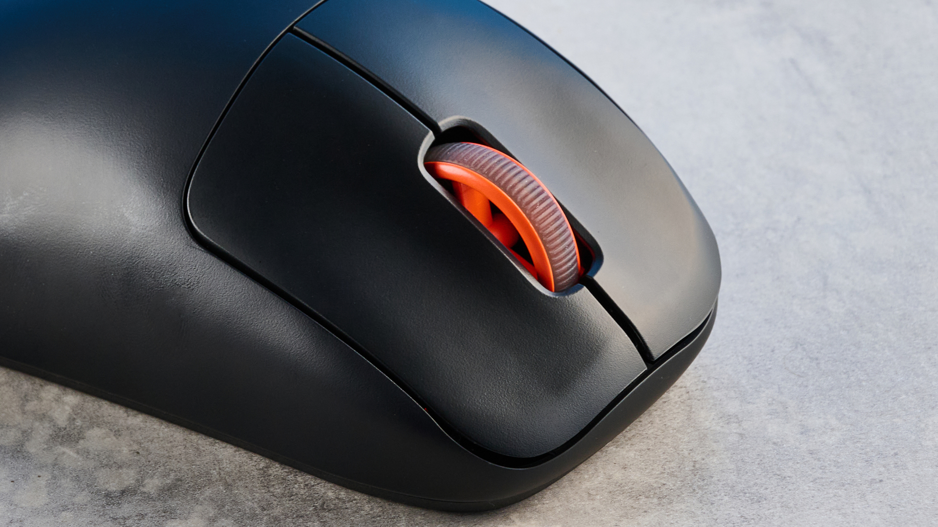 The SteelSeries Rival Pro mouse on a grey stone surface