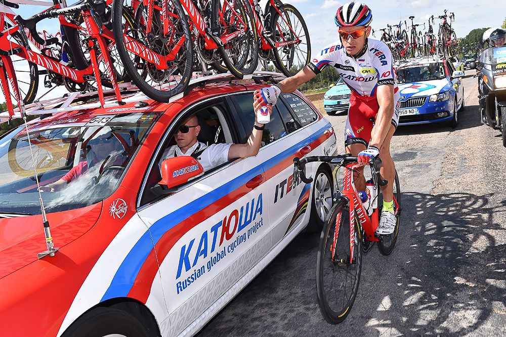 A Katusha riders gets refreshments from the team car.