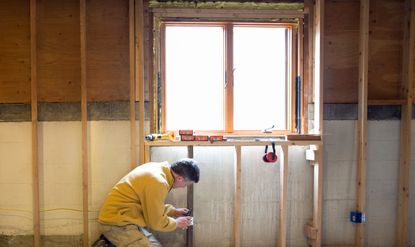 a man insulating windows in the middle of a house-build or renovation