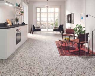 A white kitchen diner with gray terrazzo tiling demonstrating contemporary kitchen flooring ideas.