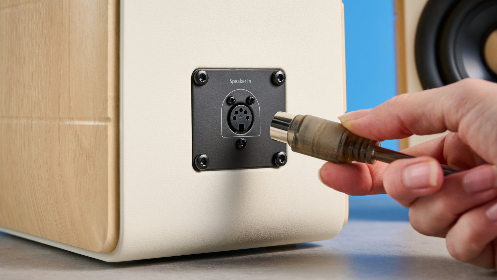 the edifier s880db mkii speakers in white and wood colorway showing the connectivity options, remote control, against a blue background