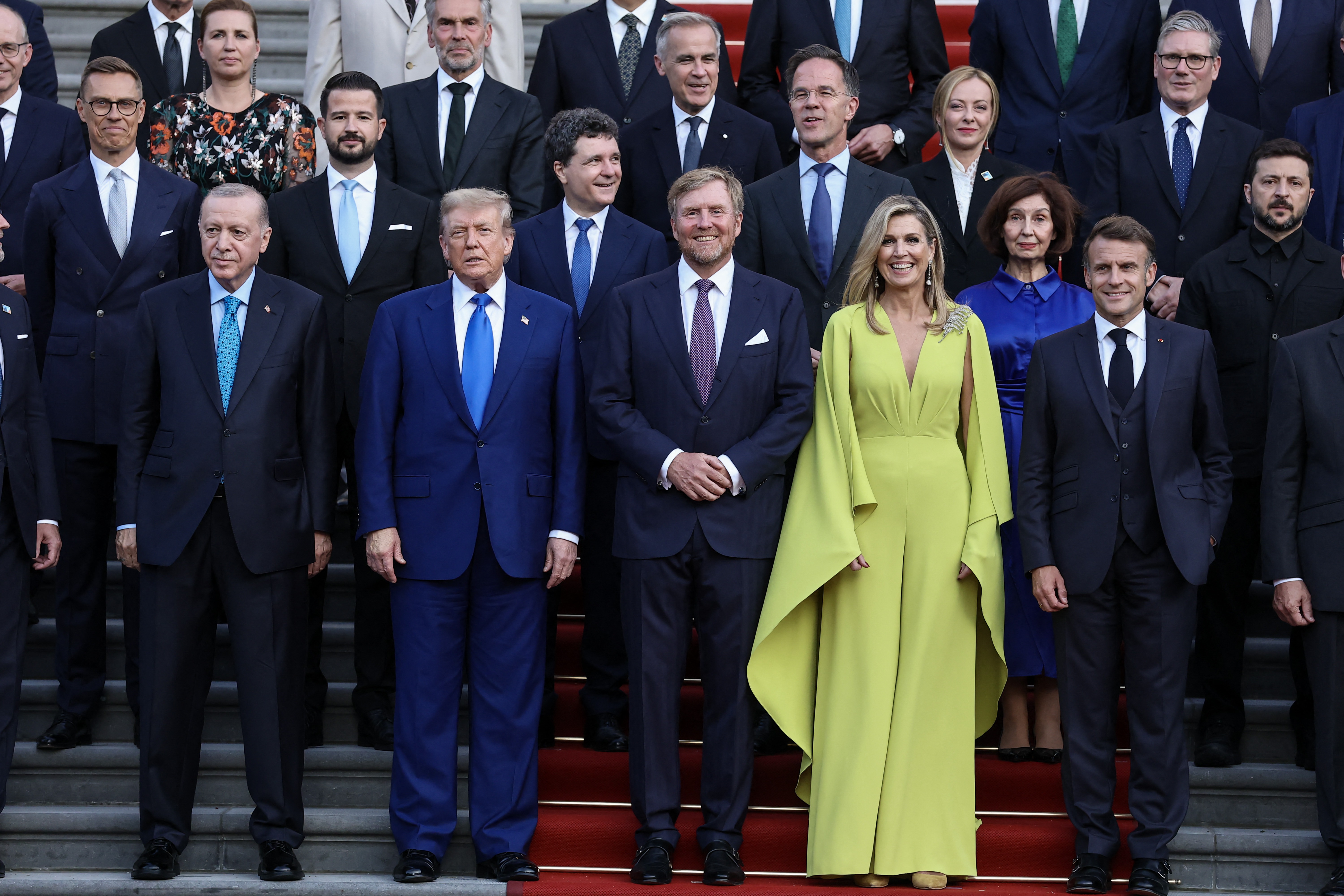 Queen Maxima wearing a lime jumpsuit posing with King Willem-Alexander, Donald Trump and other leaders at the NATO Summit