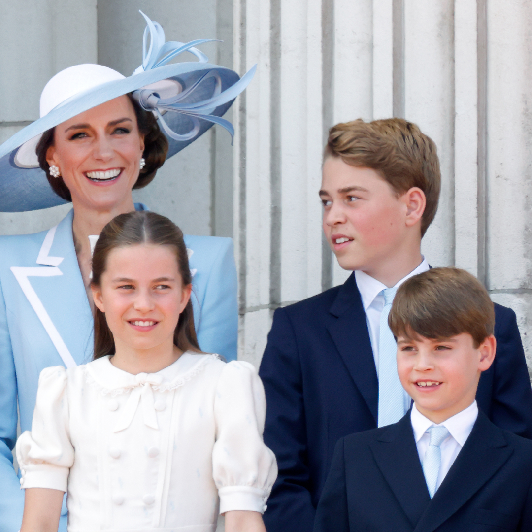 Princess Kate wearing a blue suit and hat standing with Princess Charlotte, Prince George and Prince Louis on the Buckingham Palace balcony