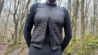 Man wearing cycling jacket standing in woods