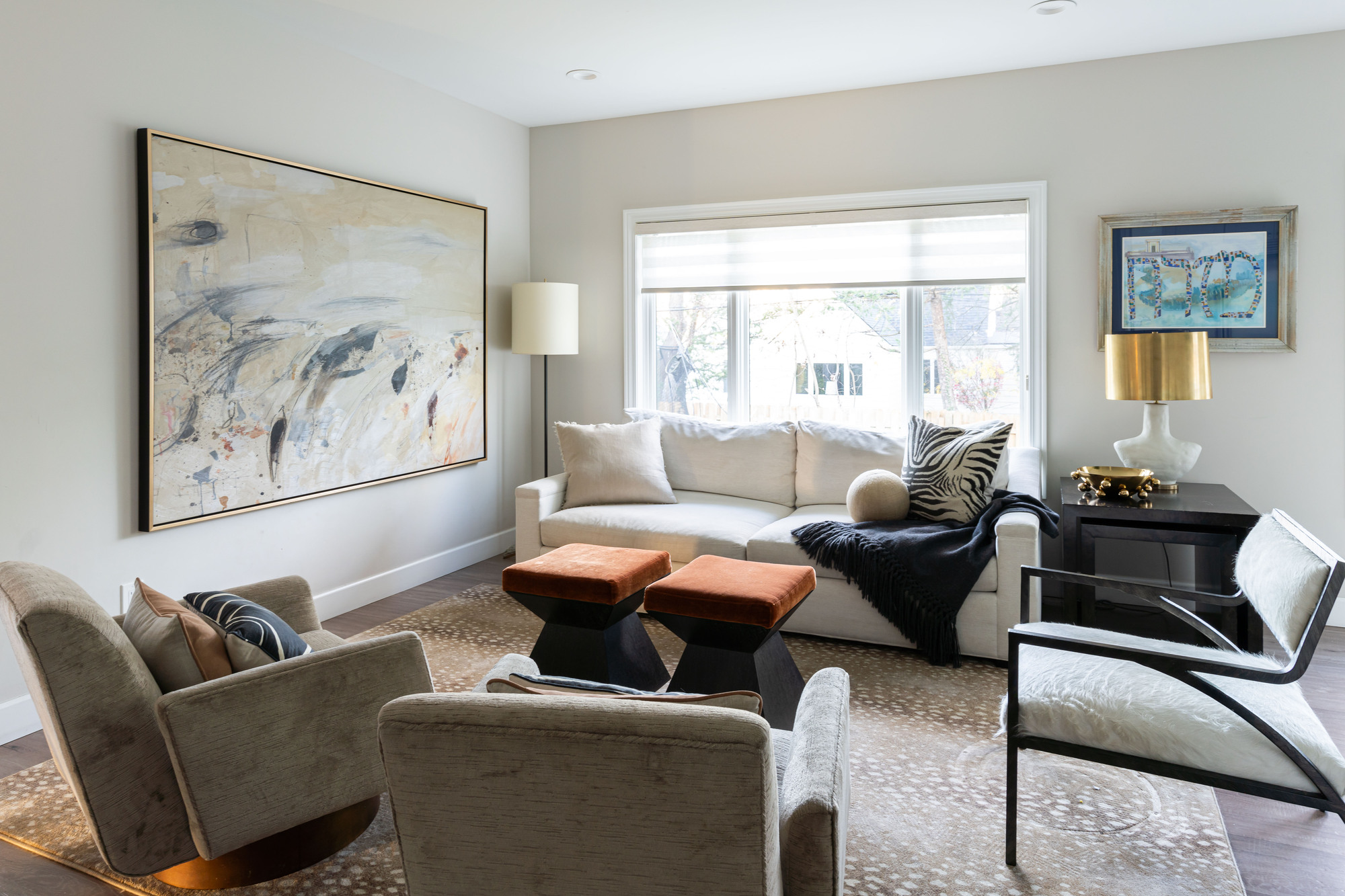 A living room with a sofa and three arm chairs