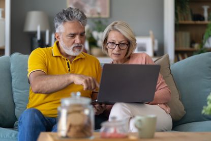 Older couple at home looking at laptop