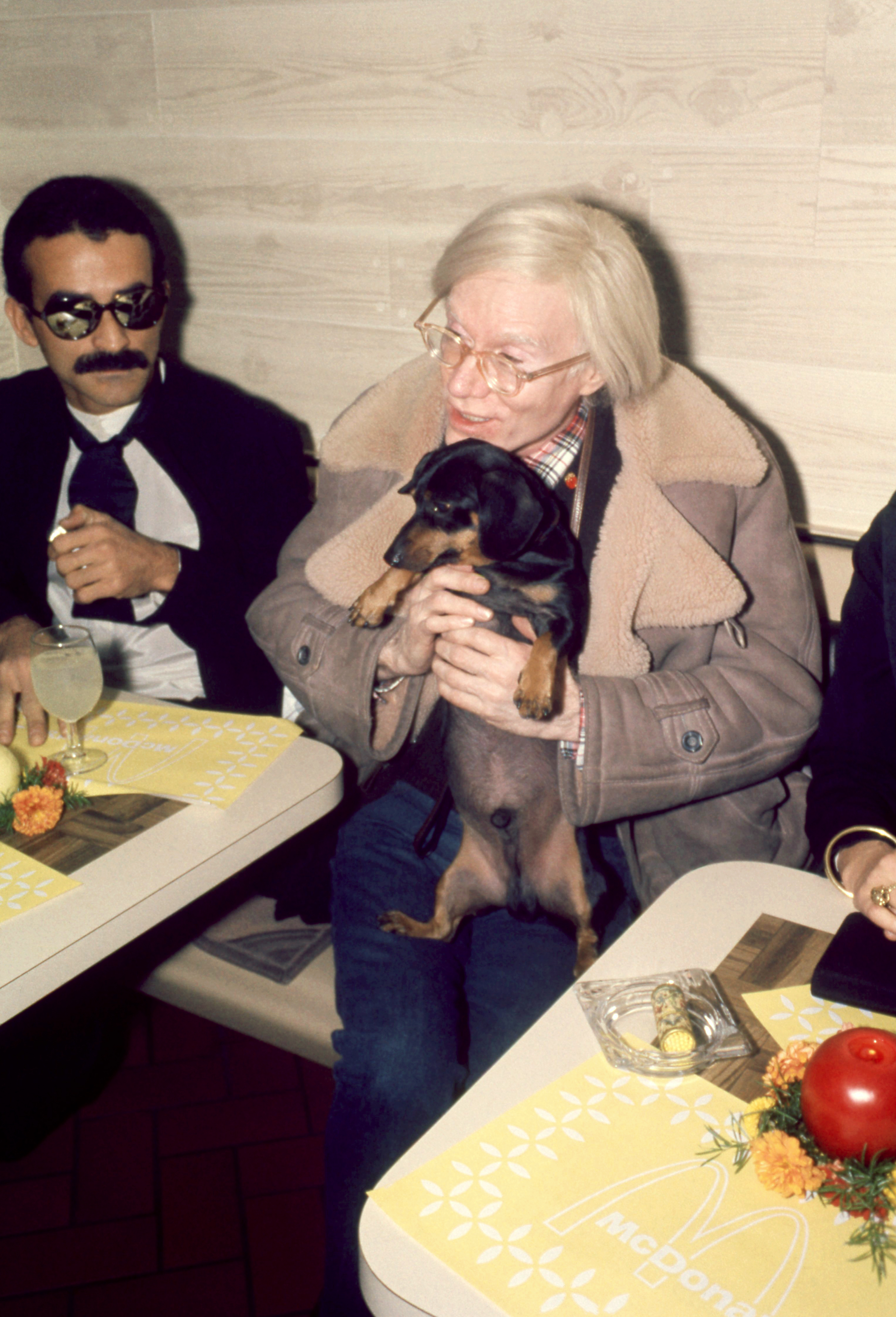 Andy Warhol and his dachshund Archie at a benefit dinner, in New York in 1976.