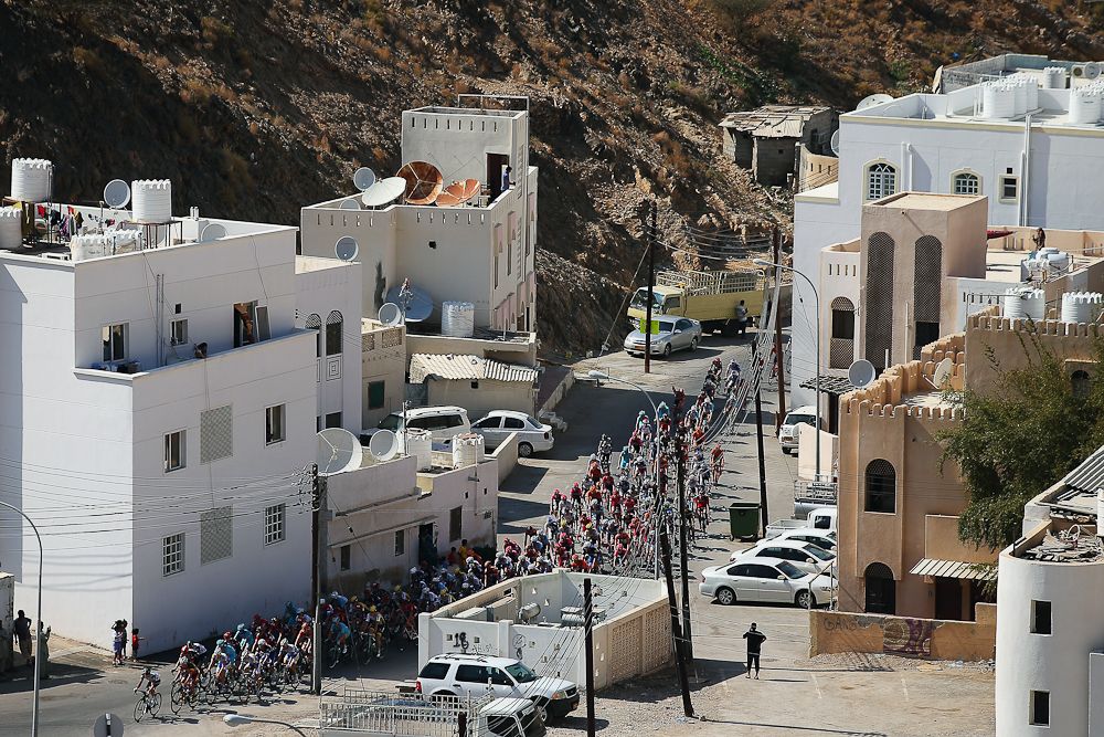 The peloton passes through the town of Al Hamriyah during stage one of the 2016 Tour of Oman