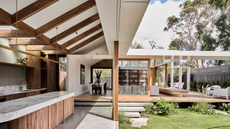 an outdoor kitchen an living area with lots of wood details