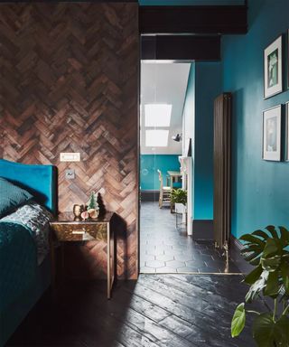 Teal, brown and black bedroom with wooden paneling by Malcolm Menzies