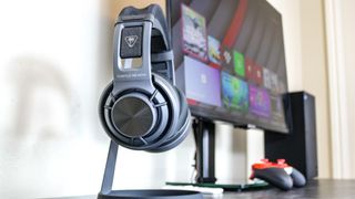 The Turtle Beach Atlas Air headset on a headphone stand next to an Xbox Series X