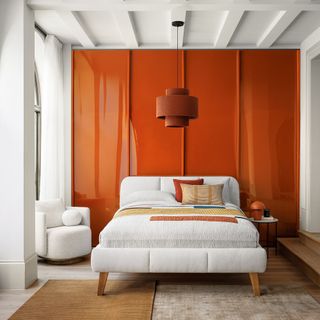 Orange wall with white ceiling and white bed