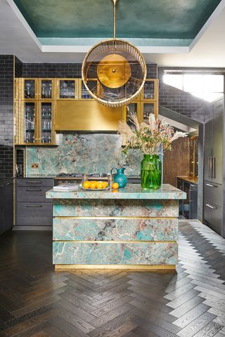 Gold and green kitchen with statement gold lighting