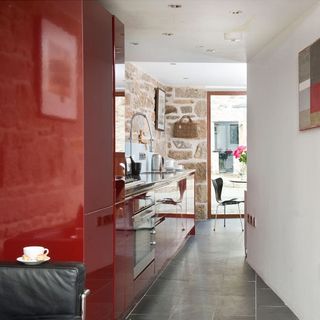 kitchen area with white wall and red cabinet