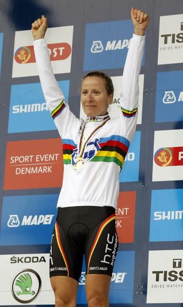 Judith Arndt waves after pulling on her rainbow jersey