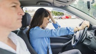 Woman failed on driving test. Driving school. Stressed and disappointed young woman failed on driving test. Student driver taking driving test