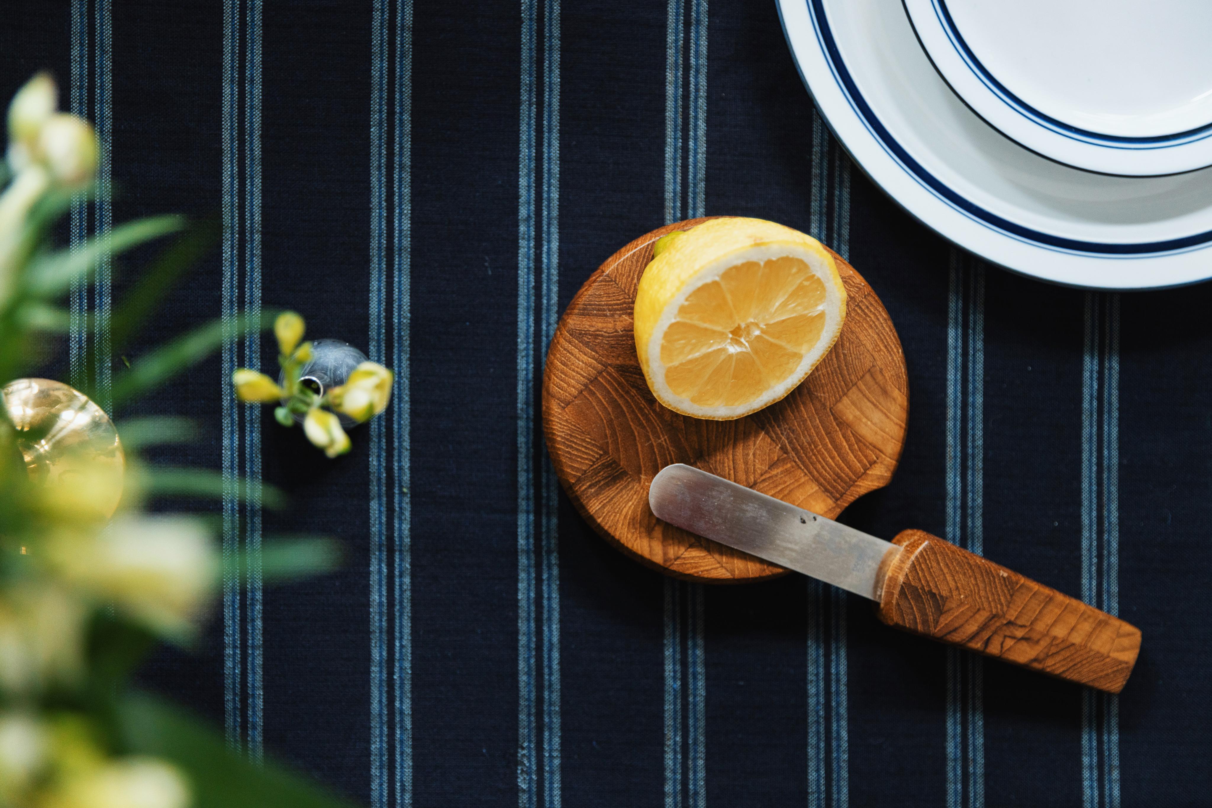 wooden chopping board and knife on a striped tablecloth