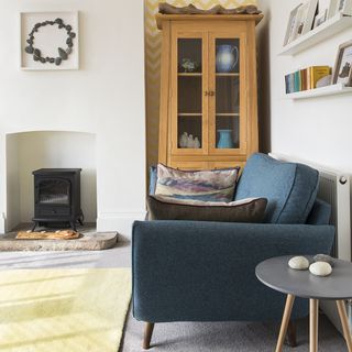 white living room with carpet flooring and blue sofa