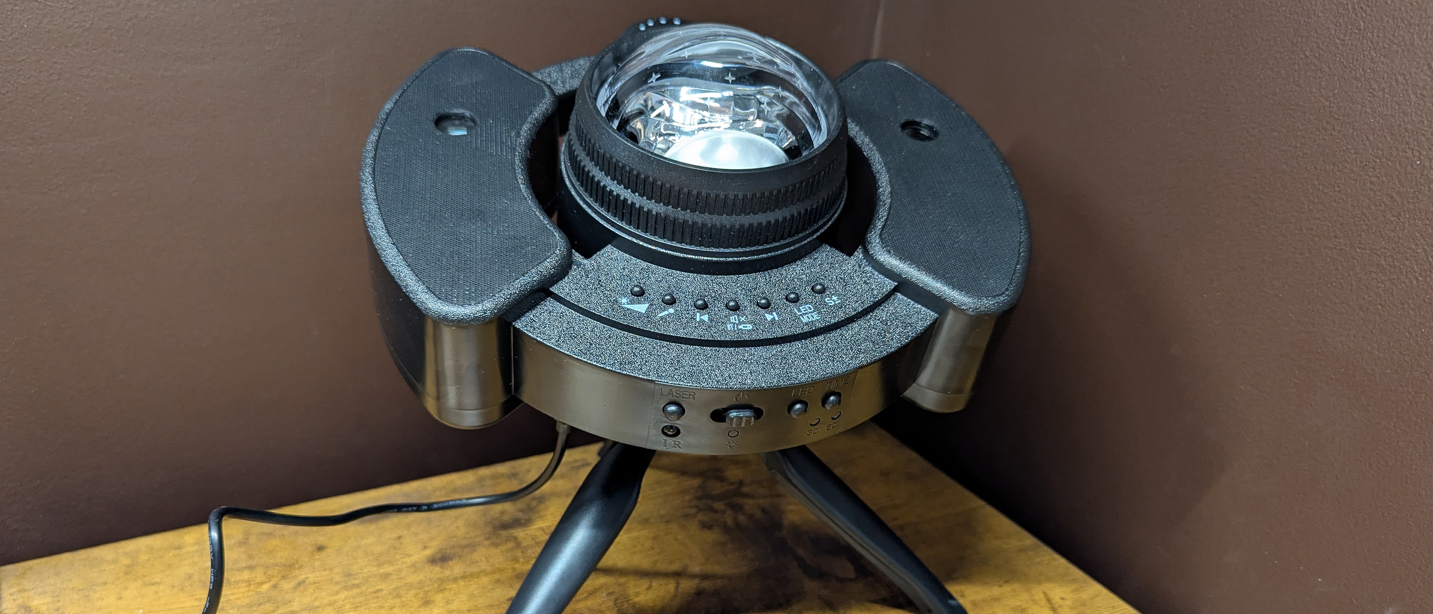 YgiTK Northern Galaxy Lights Projector during Review, on a wooden table against a dark coloured wall