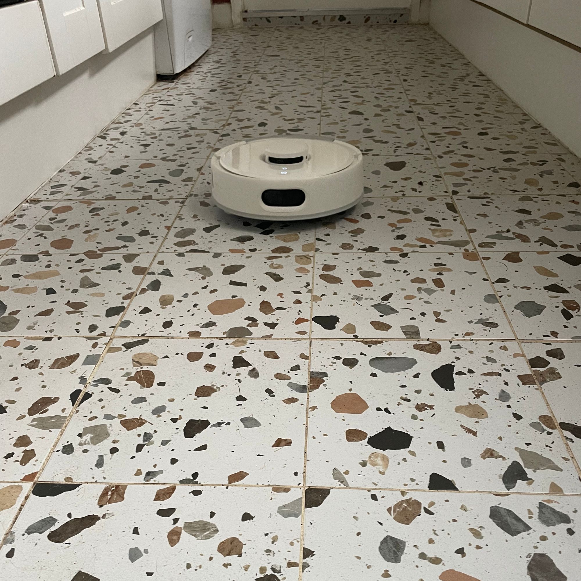 SwitchBot K11+ Robot Vacuum Cleaner with Mop cleaning a kitchen with terrazzo tiled floors